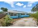 Charming blue single-story house featuring solar panels and a well-maintained yard at 6132 7Th S Ave, Gulfport, FL 33707
