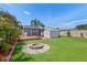 Backyard with a fire pit, shed, and manicured landscaping at 6183 5Th S Ave, St Petersburg, FL 33707