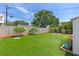 A large green backyard with a wooden fence and a fire pit at 6183 5Th S Ave, St Petersburg, FL 33707