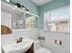 Bathroom with white tile, updated sink, faucet, and natural light from the window at 6183 5Th S Ave, St Petersburg, FL 33707