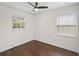 Bedroom with hardwood floors, ceiling fan, and two bright windows at 6183 5Th S Ave, St Petersburg, FL 33707