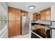 Traditional kitchen features wood cabinets, black counters, stainless steel appliances, and tile backsplash at 6183 5Th S Ave, St Petersburg, FL 33707