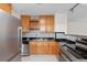 Bright kitchen with wood cabinets, black counters, stainless steel appliances, and a tiled backsplash at 6183 5Th S Ave, St Petersburg, FL 33707