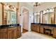 Luxurious primary bathroom with dual sinks, wooden cabinetry, and elegant lighting fixtures at 704 Berrocales De Avila, Tampa, FL 33613