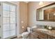 Bathroom features a door to the outside, granite countertops, wood cabinets, and mirror at 704 Berrocales De Avila, Tampa, FL 33613