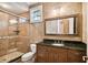 Bathroom featuring a tiled walk-in shower, vanity with dark granite countertops, and a large mirror at 704 Berrocales De Avila, Tampa, FL 33613