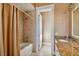Bathroom with a tub shower and a vanity with tan granite countertops and white cabinets at 704 Berrocales De Avila, Tampa, FL 33613