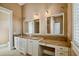Double vanity bathroom with elegant white cabinets and granite countertops with a makeup table at 704 Berrocales De Avila, Tampa, FL 33613
