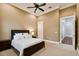 Cozy bedroom with neutral walls, carpet, a dark wood bed frame and a view into the ensuite bathroom at 704 Berrocales De Avila, Tampa, FL 33613