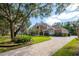 Charming home exterior with mature landscaping, brick driveway, and well-kept lawn at 704 Berrocales De Avila, Tampa, FL 33613