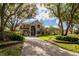 Beautiful home with mature trees, lush landscaping, and a circular driveway at 704 Berrocales De Avila, Tampa, FL 33613
