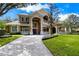 Stately home with a grand entrance, manicured lawn, and circular driveway at 704 Berrocales De Avila, Tampa, FL 33613