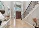 Elegant foyer with grand staircase, and natural light at 704 Berrocales De Avila, Tampa, FL 33613