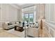 Bright living room with neutral decor, wainscoting, and French doors to the patio and pool at 704 Berrocales De Avila, Tampa, FL 33613