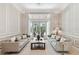 Bright living room with neutral furniture, and doors to the lanai at 704 Berrocales De Avila, Tampa, FL 33613