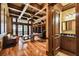 An office with a coffered ceiling, wood floors, access to a bathroom, and a large built-in bookcase at 704 Berrocales De Avila, Tampa, FL 33613