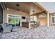 Inviting outdoor patio with seating area, outdoor kitchen and a view of the screened pool at 704 Berrocales De Avila, Tampa, FL 33613