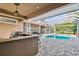 Luxury outdoor patio with outdoor kitchen, bar area and a screened-in pool at 704 Berrocales De Avila, Tampa, FL 33613