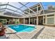 Stunning backyard oasis with a sparkling pool, covered patio, and outdoor bar, perfect for entertaining guests at 704 Berrocales De Avila, Tampa, FL 33613