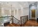 Staircase with wood steps and wrought iron railing with a chandelier at 704 Berrocales De Avila, Tampa, FL 33613