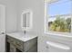 Well-lit bathroom featuring a modern vanity with stone countertops and LED mirror at 718 Desert Hills Way, Sun City Center, FL 33573