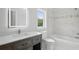Stylish bathroom features a marble backsplash, a large vanity, and a bathtub at 718 Desert Hills Way, Sun City Center, FL 33573