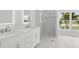 Elegant bathroom with double vanity, frameless shower and bright natural light at 718 Desert Hills Way, Sun City Center, FL 33573