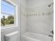 Bright bathroom with marble tiling around the tub and shower at 718 Desert Hills Way, Sun City Center, FL 33573