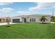 Charming single story home with a well-manicured lawn, a modern front door, and gray garage door at 718 Desert Hills Way, Sun City Center, FL 33573
