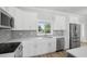 Bright, newly remodeled kitchen featuring stainless steel appliances, quartz counters, and gray backsplash at 718 Desert Hills Way, Sun City Center, FL 33573