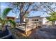 Backyard wooden deck next to the home, partially shaded by trees and lush tropical vegetation at 8296 33Rd N Ave, St Petersburg, FL 33710