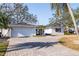 Lovely home featuring a white brick facade, two car garage, and paved driveway, nestled among mature trees at 8296 33Rd N Ave, St Petersburg, FL 33710