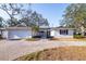 Charming single-story home featuring a white brick facade, well-manicured landscaping, and a paved driveway at 8296 33Rd N Ave, St Petersburg, FL 33710