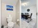 Cozy half bath with a toilet and decorative painting overlooking the dining room at 841 Royal Empress Dr, Ruskin, FL 33570