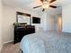 Bedroom featuring a dresser with a mirror, flatscreen TV, cozy chair, carpet, and ceiling fan at 841 Royal Empress Dr, Ruskin, FL 33570