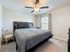 Bedroom with a large window, decorative curtains, neutral carpet, ceiling fan, dresser, and a cozy chair at 841 Royal Empress Dr, Ruskin, FL 33570