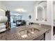 Stylish kitchen features granite countertops, a stainless steel sink, and an open layout to the living areas at 841 Royal Empress Dr, Ruskin, FL 33570