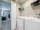 Laundry room with full-size washer and dryer, overhead shelving for supplies, adjacent to bedroom at 841 Royal Empress Dr, Ruskin, FL 33570