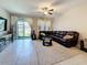 Bright living area with sliding glass doors to backyard, ceiling fan, tile floors, and sectional sofa at 841 Royal Empress Dr, Ruskin, FL 33570