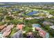 Expansive aerial view showcasing a luxurious community with a golf course, lakes, and verdant tree coverage at 9075 Waterash N Ln, Pinellas Park, FL 33782