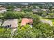 Beautiful aerial view of a home with a red tile roof surrounded by mature trees at 9075 Waterash N Ln, Pinellas Park, FL 33782