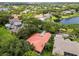Aerial view showcasing the home's red roof, mature landscaping, and neighborhood at 9075 Waterash N Ln, Pinellas Park, FL 33782