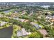 Breathtaking aerial view featuring residences nestled among mature trees, a tranquil lake, and a scenic golf course at 9075 Waterash N Ln, Pinellas Park, FL 33782