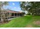 Well-maintained backyard with a screened-in pool, mature trees, and lush lawn at 9075 Waterash N Ln, Pinellas Park, FL 33782