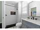 Modern bathroom featuring white subway tile shower, black accents, and marble countertop vanity at 9075 Waterash N Ln, Pinellas Park, FL 33782