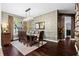 Dining area featuring hardwood floors, textured wall, and a modern chandelier over a wooden table at 9075 Waterash N Ln, Pinellas Park, FL 33782