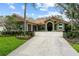 Charming single-story home featuring lush landscaping, a terracotta roof, and an attached two-car garage at 9075 Waterash N Ln, Pinellas Park, FL 33782