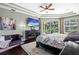 Bright main bedroom features dark wood furniture, a tray ceiling, a ceiling fan, and a TV at 9075 Waterash N Ln, Pinellas Park, FL 33782