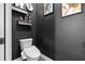Elegant powder room featuring dark gray walls, modern toilet, and stylish decor at 9075 Waterash N Ln, Pinellas Park, FL 33782