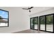 Bright bedroom with a modern ceiling fan, large windows, and sliding glass doors leading to a balcony at 908 W Fribley St, Tampa, FL 33603